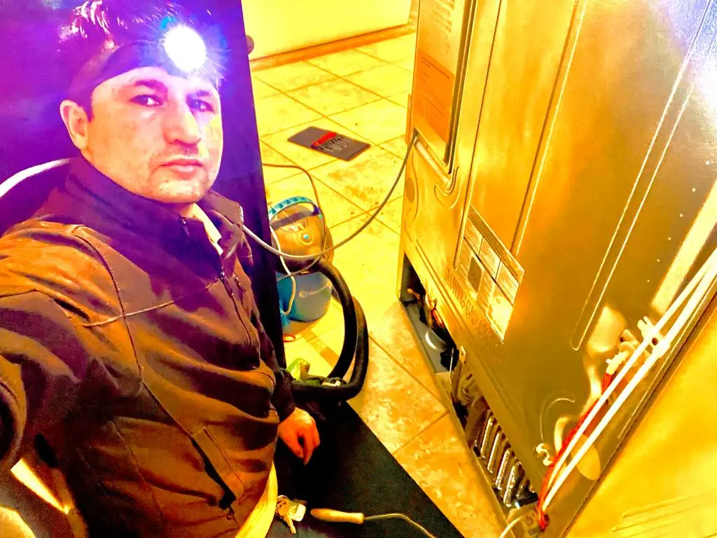 A technician working on a refrigerator