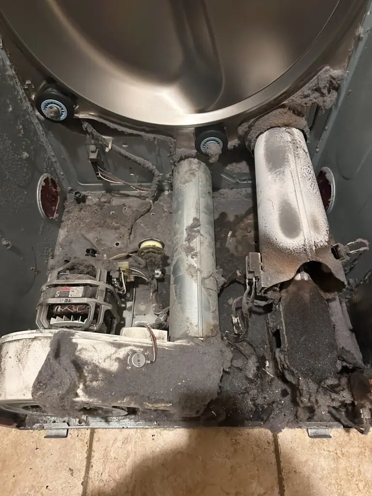 Dryer with heavy lint buildup behind the drum (job photo)